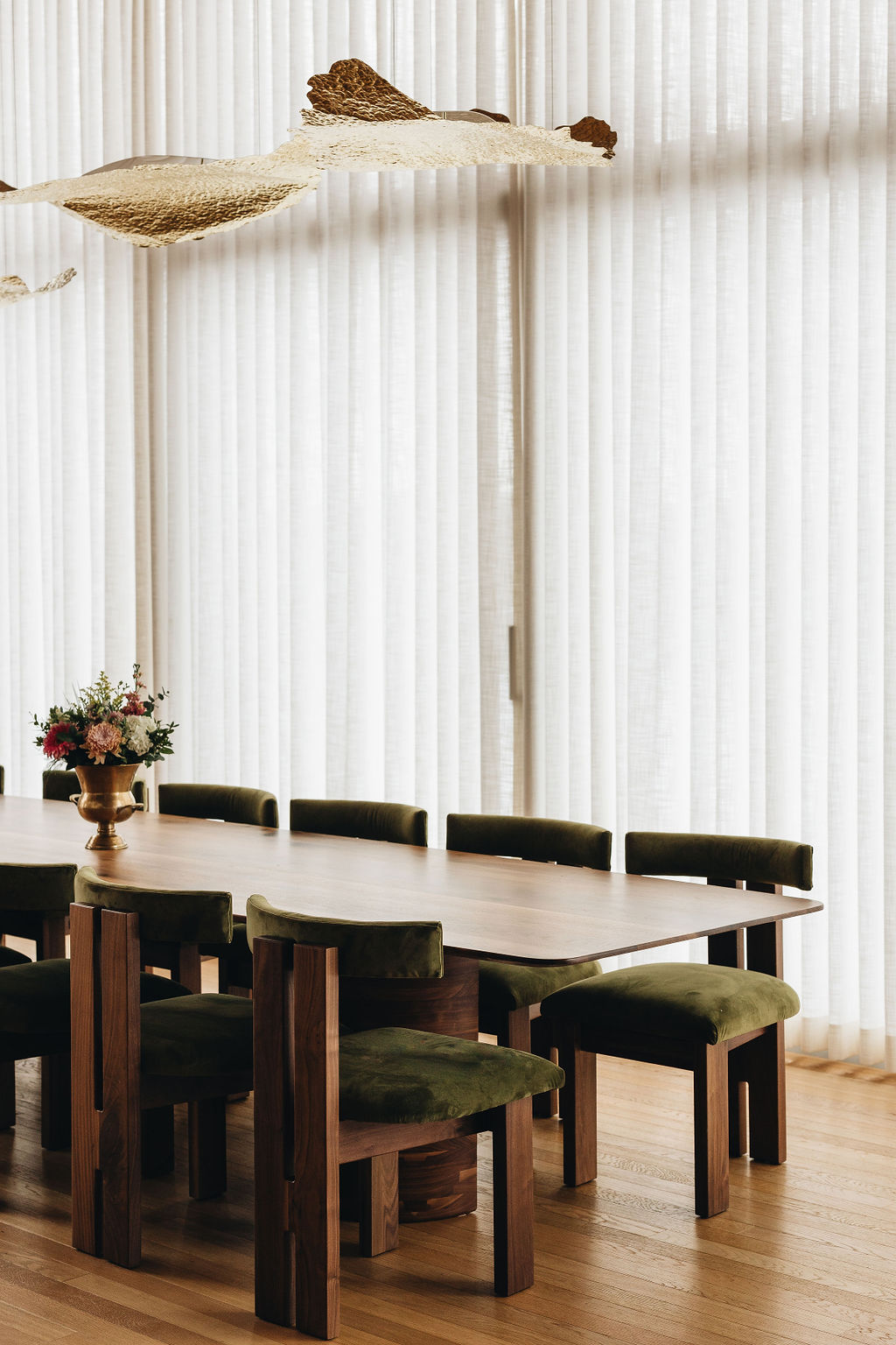 Elegant live edge dining table with green upholstered chairs in a modern Toronto home.
