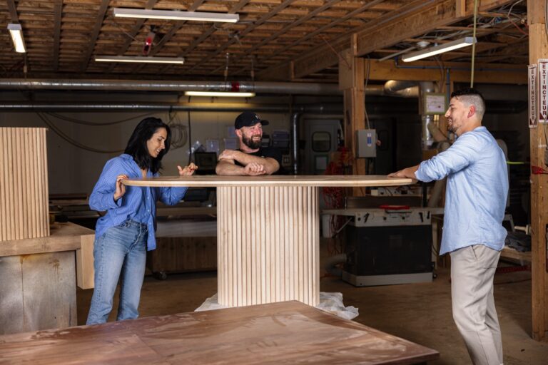 Woodworkers collaborating in an Toronto workshop while building a handcrafted live edge table.