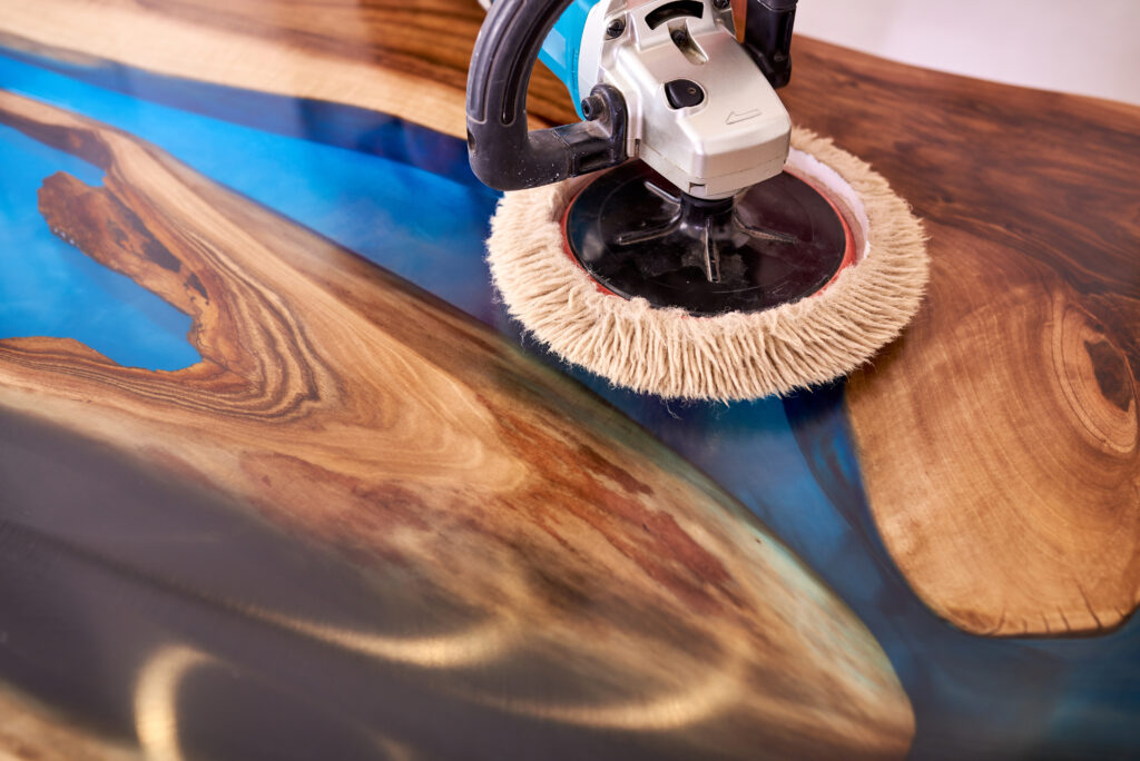 Polishing a custom epoxy and wood live edge table in Toronto to achieve a high-gloss finish.