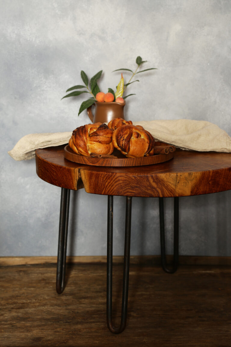 Round live edge table in Toronto with metal hairpin legs, styled with fresh pastries and fruit.